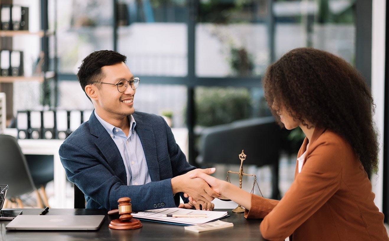 Abogado estrechando la mano de cliente en acuerdo legal.