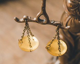 Balanza dorada de la justicia sobre fondo desenfocado.